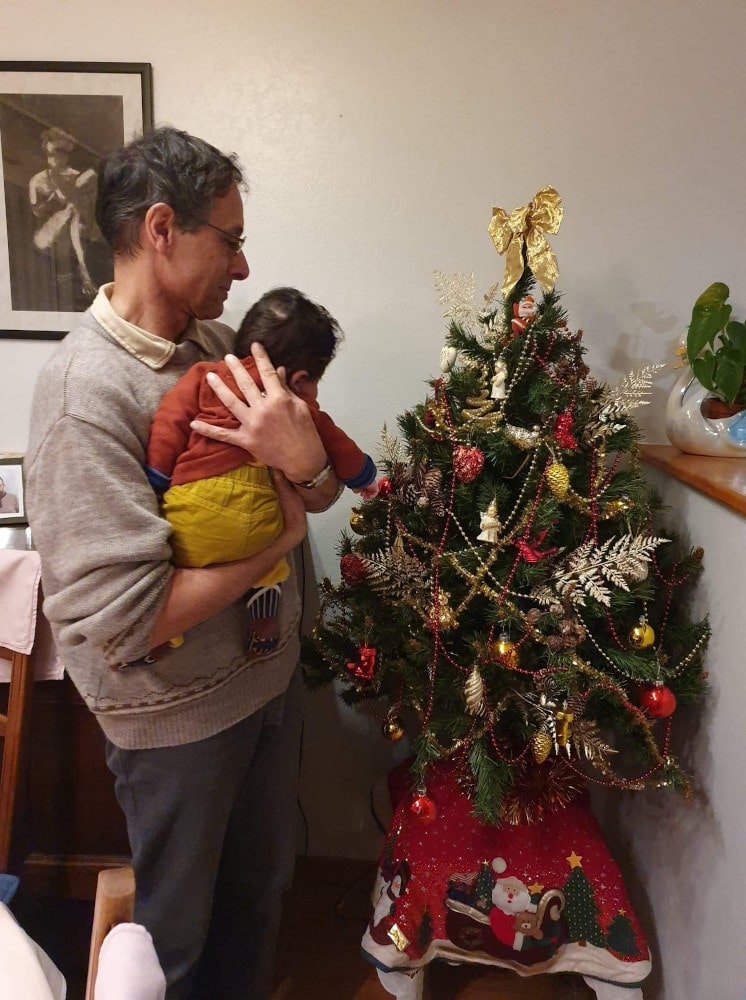 Adao regarde le sapin dans les bras de Jean-François